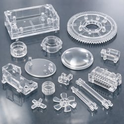Clear plastic molded parts showing transparency and defects like streaking and haze caused by contamination during processing.