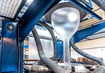 Blown film extrusion line producing a plastic film bubble while reducing gels, black specks, and startup scrap through effective purging.