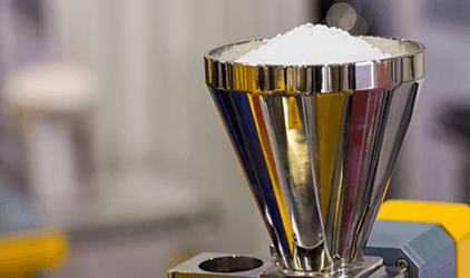Plastic resin pellets and purging concentrate used to clean injection molding or extrusion equipment.