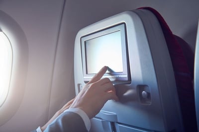 passenger using touchscreen on plane