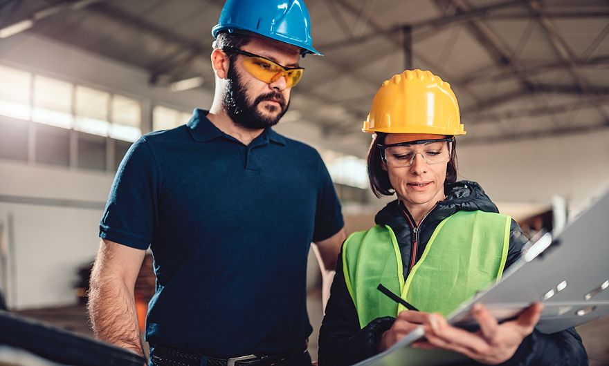 employees in a warehouse reviewing plans